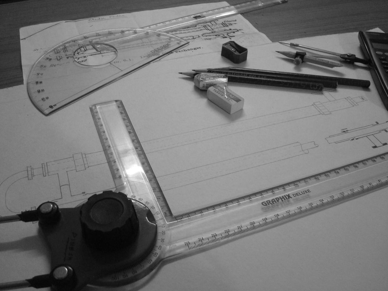 Engineering drafting tools and technical drawings on a desk